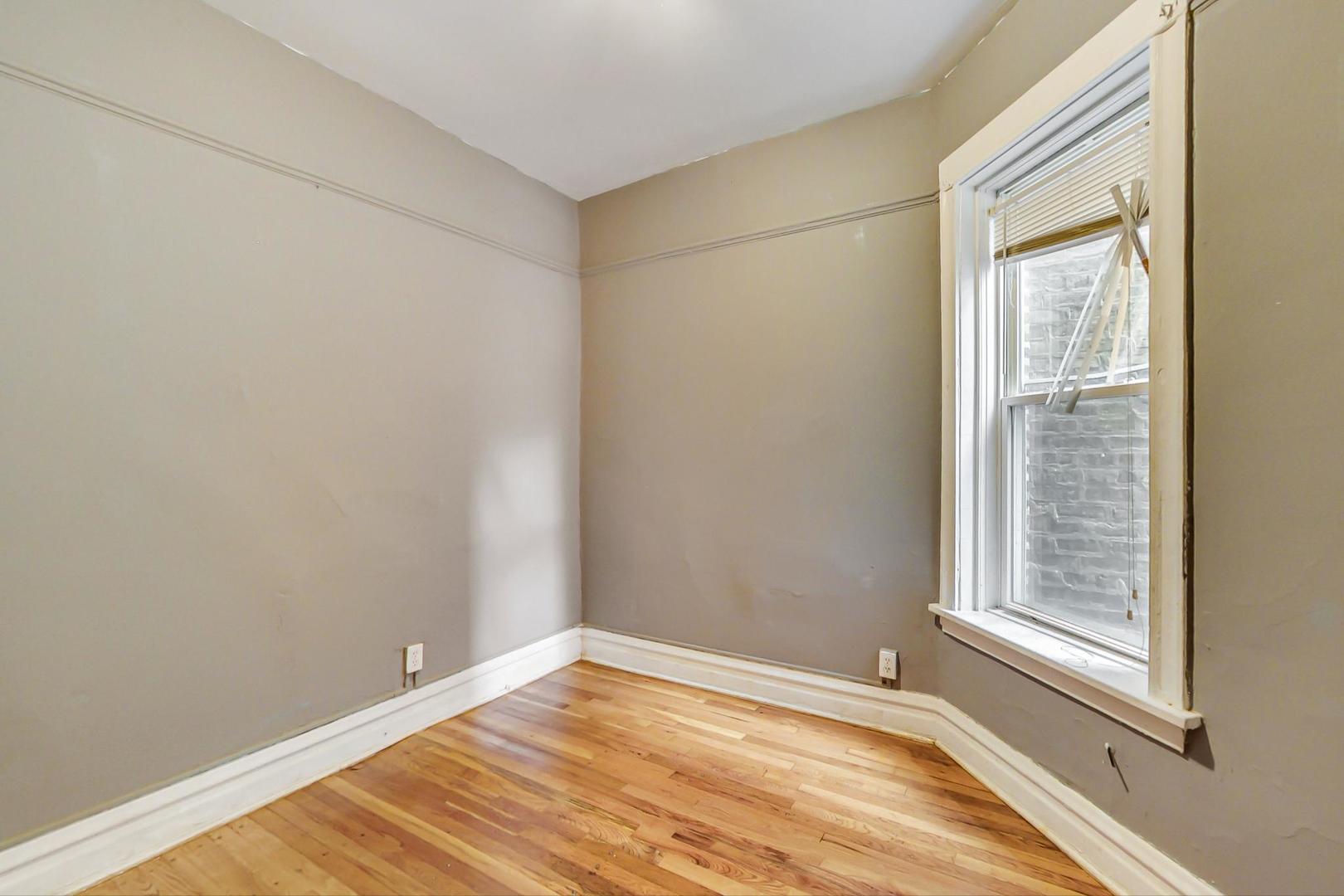 719 North Ridgeway Avenue Chicago, IL 60624 - Photo 19 of 58 a view of an empty room with wooden floor and a window