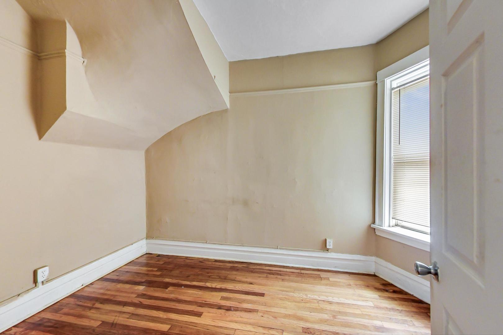 719 North Ridgeway Avenue Chicago, IL 60624 - Photo 21 of 58 an empty room with wooden floor and windows