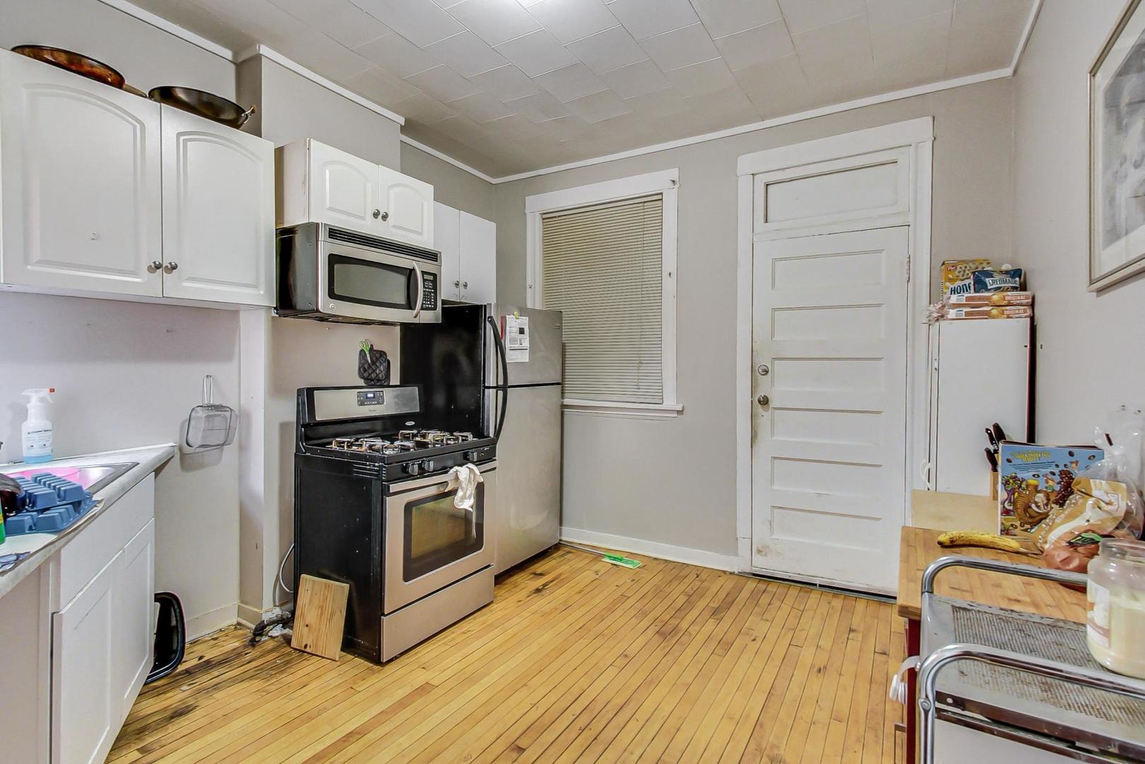 719 North Ridgeway Avenue Chicago, IL 60624 - Photo 41 of 58 a kitchen with stainless steel appliances and wooden floor