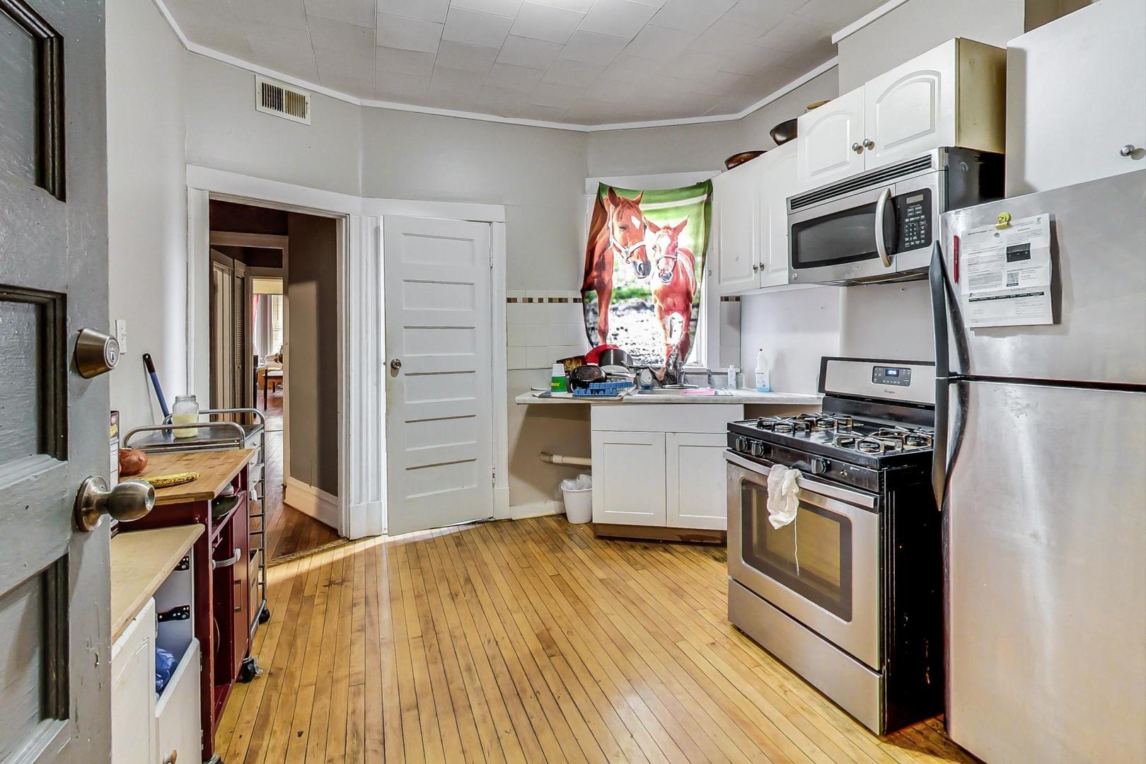 719 North Ridgeway Avenue Chicago, IL 60624 - Photo 42 of 58 a kitchen with stainless steel appliances a stove microwave and a refrigerator