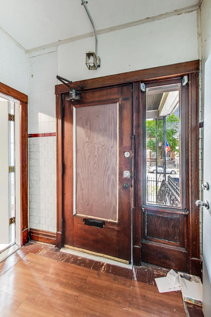 719 North Ridgeway Avenue Chicago, IL 60624 - Photo 8 of 58 an empty room with wooden floor and windows