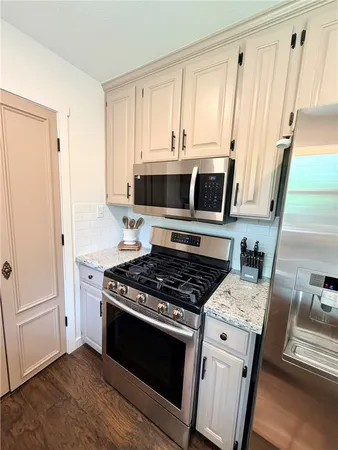 a kitchen with stainless steel appliances granite countertop a sink stove and cabinets