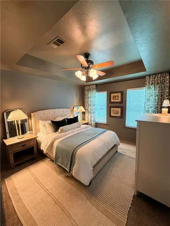 a bedroom with a large bed and a chandelier