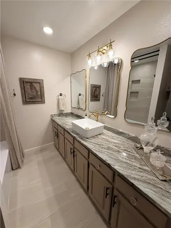 a bathroom with double vanity sinks a vanity a lamp and a mirror