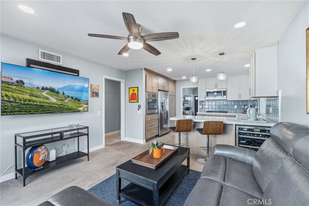 7 Spring Buck Irvine, CA 92614 - Photo 6 of 51 a living room with furniture and a flat screen tv with kitchen view