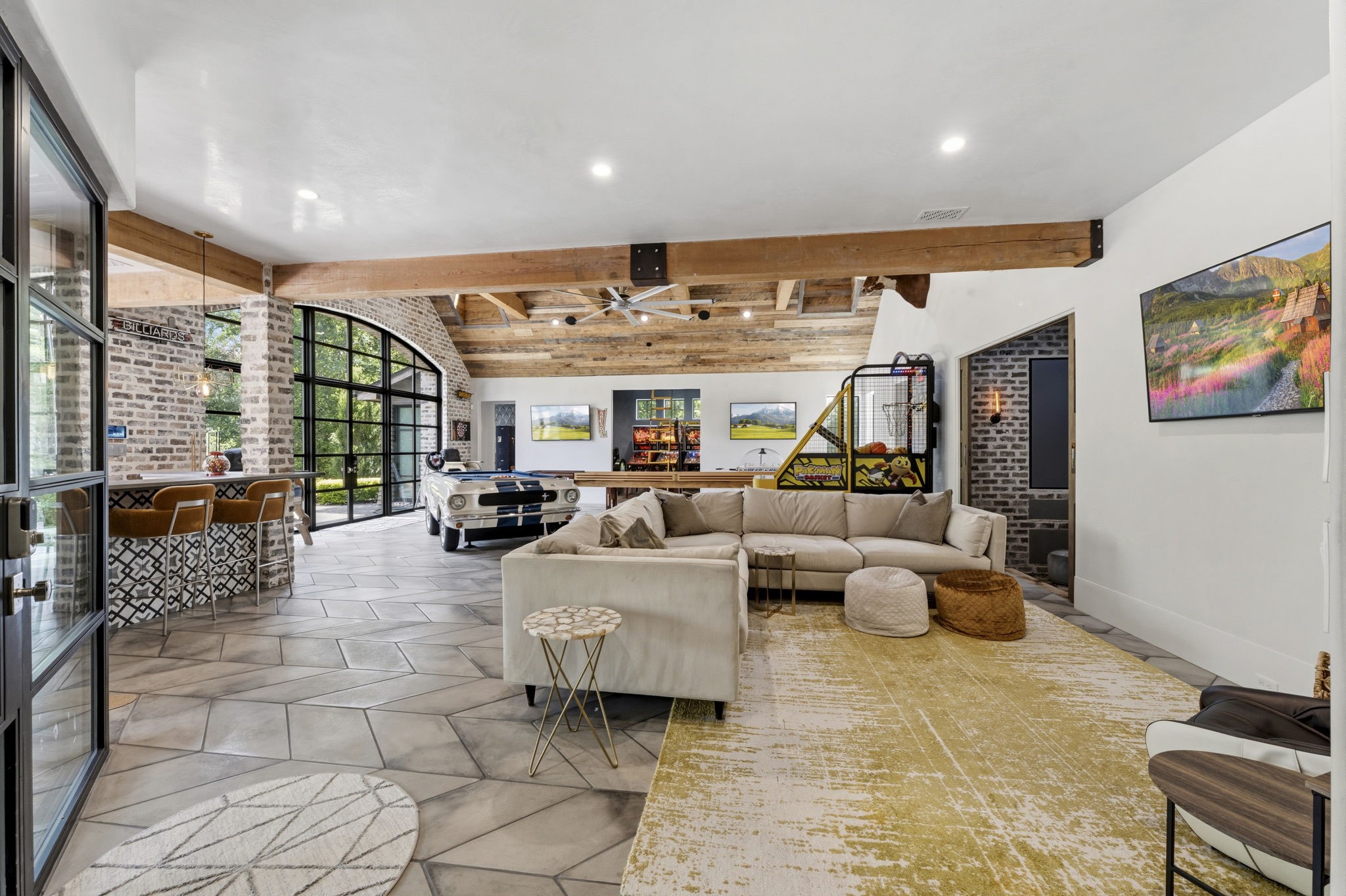 27006 Star Gazer Way Spring, TX 77386 - Photo 7 of 50 An exceptional entertainment space featuring Ann Saks custom concrete paver flooring, a reclaimed barn wood ceiling, real cedar beams, three TVs, and a spacious layout designed for unforgettable gatherings.