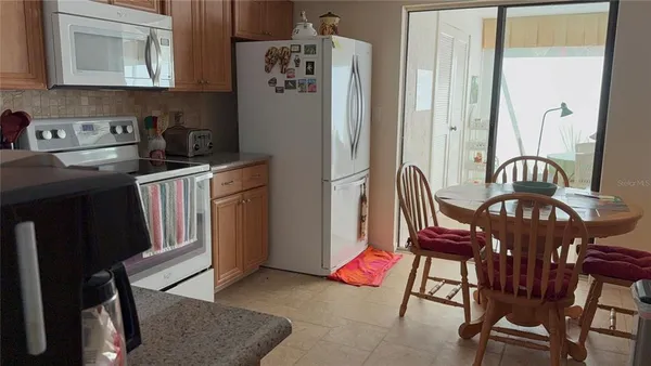 a kitchen with stainless steel appliances granite countertop a table chairs in it and wooden floors