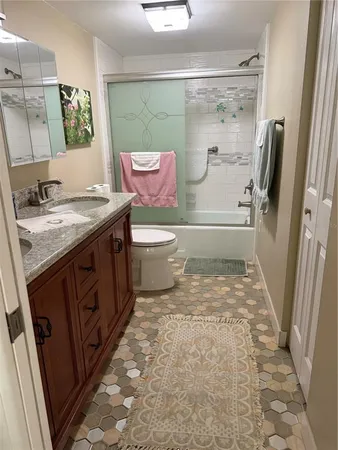 a bathroom with a granite countertop toilet sink and shower