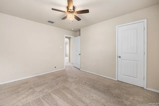 an empty room with a ceiling fan and a window