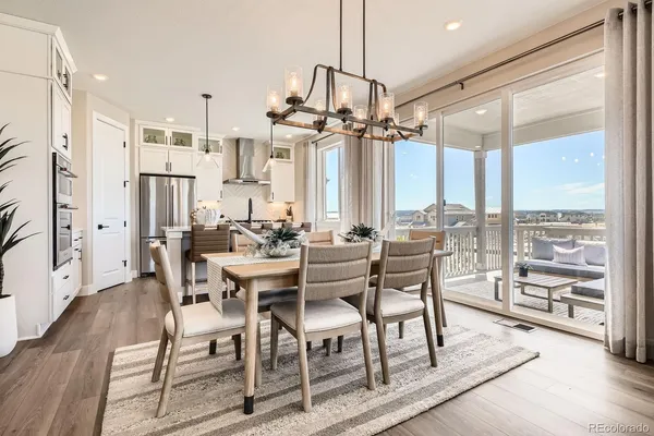 a view of a dining room and livingroom with furniture wooden floor a chandelier