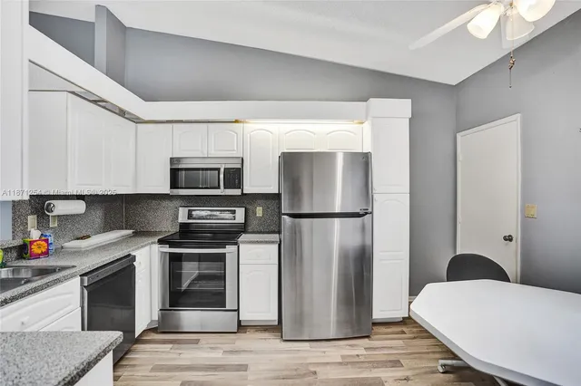 a view of a dining room with furniture and a chandelier fan