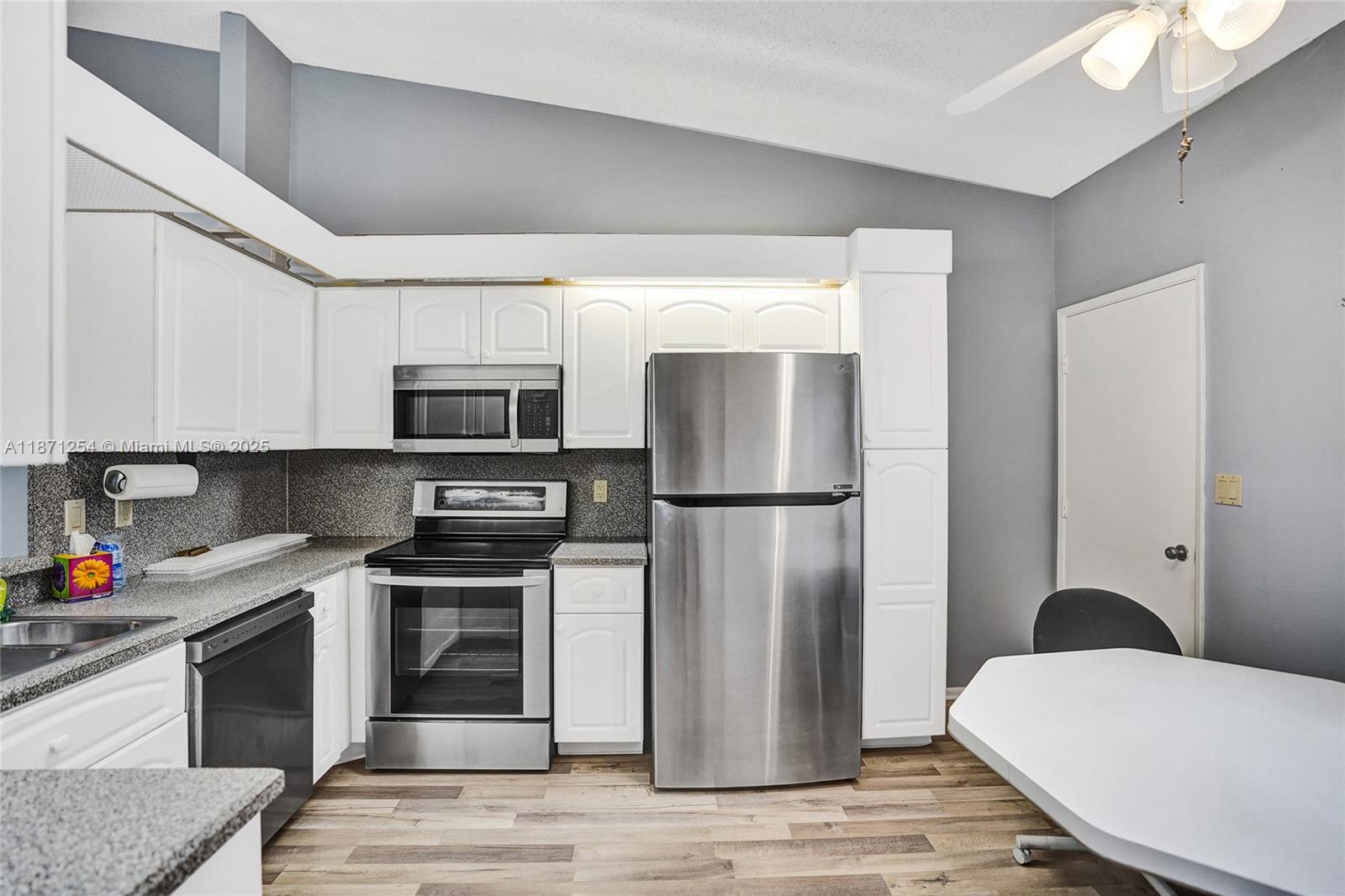 6139 Sunrise Pointe Court, Unit A Delray Beach, FL 33484 - Photo 15 of 41 a kitchen with stainless steel appliances a refrigerator stove and microwave
