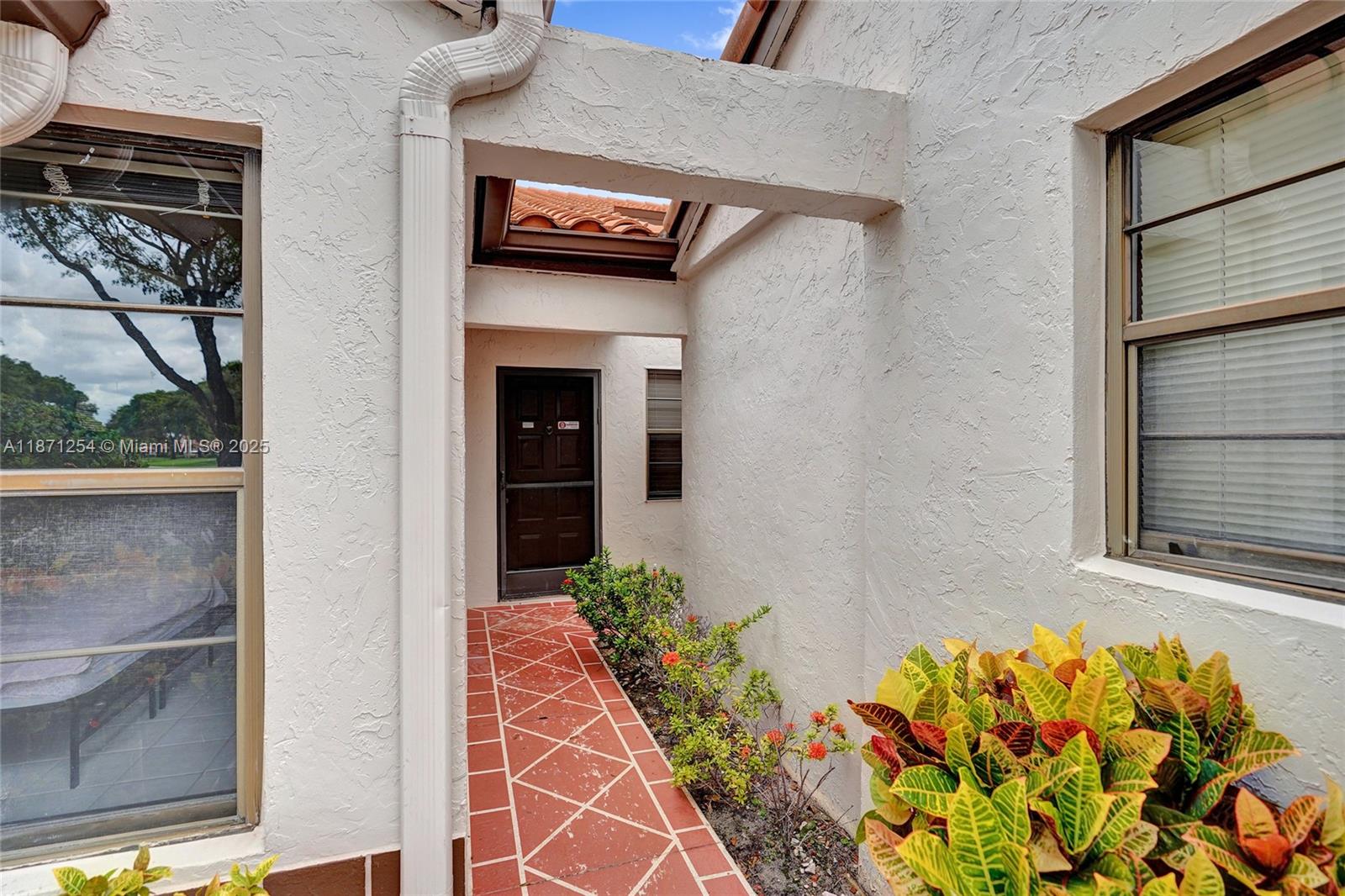 6139 Sunrise Pointe Court, Unit A Delray Beach, FL 33484 - Photo 4 of 41 a vase with flowers sitting on a floor in front of a door