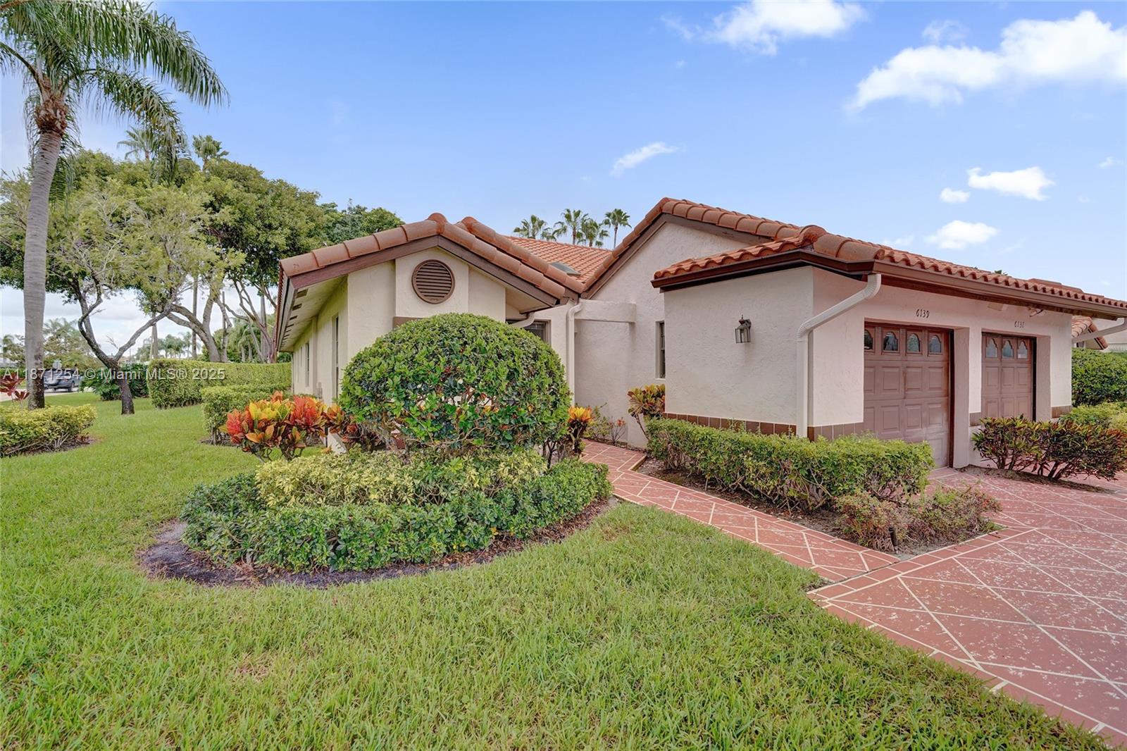 6139 Sunrise Pointe Court, Unit A Delray Beach, FL 33484 - Photo 41 of 41 a front view of a house with a garden