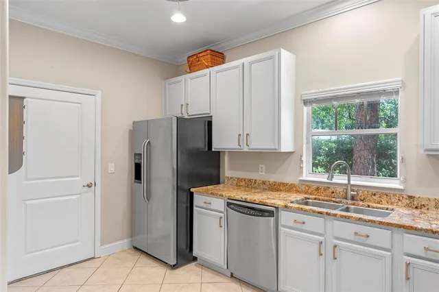 a kitchen with a refrigerator sink and cabinets
