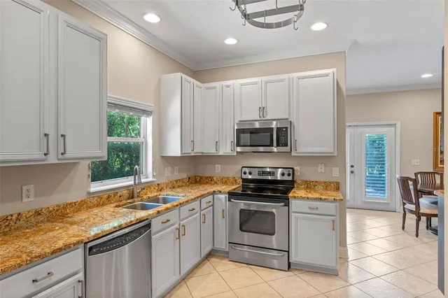 a kitchen with stainless steel appliances granite countertop a stove a sink and a microwave