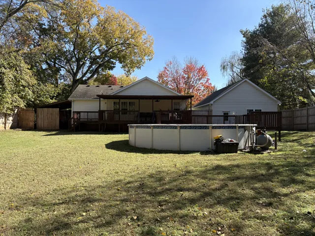 a view of a house with a yard covered with large trees
