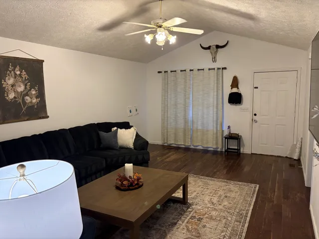 a living room with furniture and wooden floor
