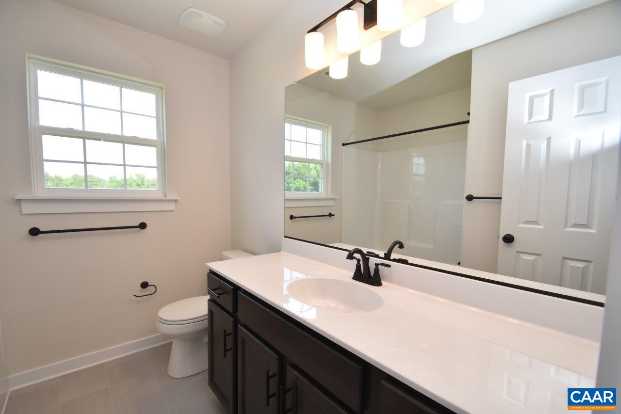 3124 Carysbrook Road, Unit CBE1 Palmyra, VA 22963 - Photo 16 of 32 a bathroom with a sink a toilet a mirror and a window