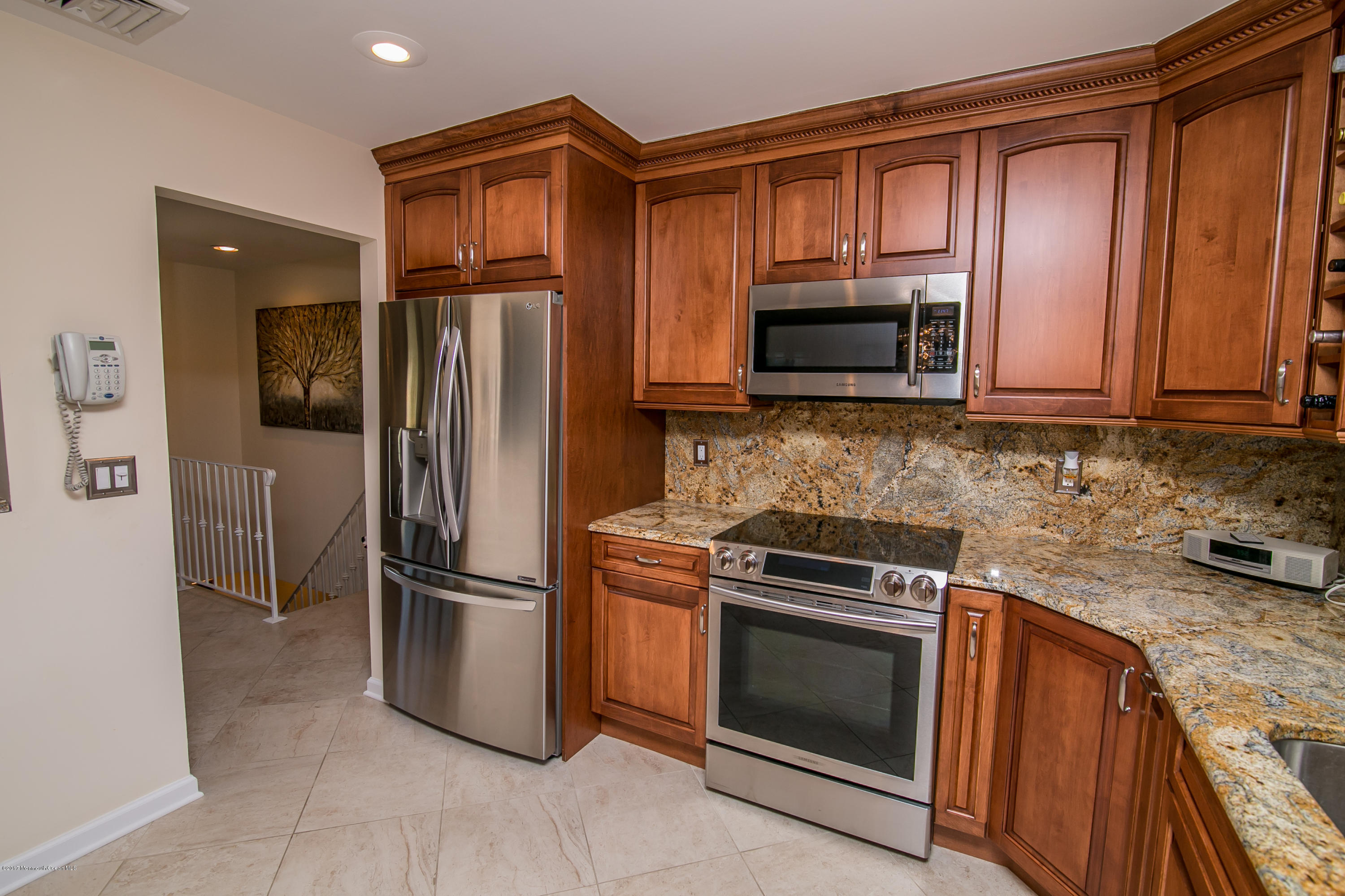 473 Lloyd Road Aberdeen, NJ 07747 - Photo 14 of 34 a kitchen with granite countertop stainless steel appliances and wooden cabinets