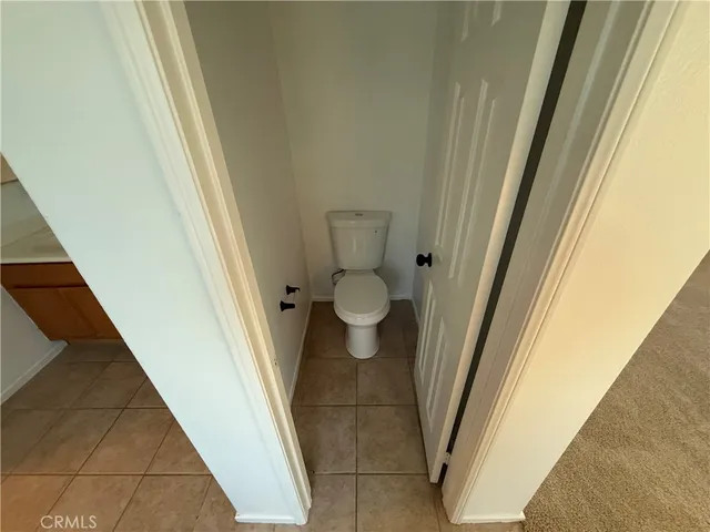 a bathroom with a granite countertop toilet and a sink