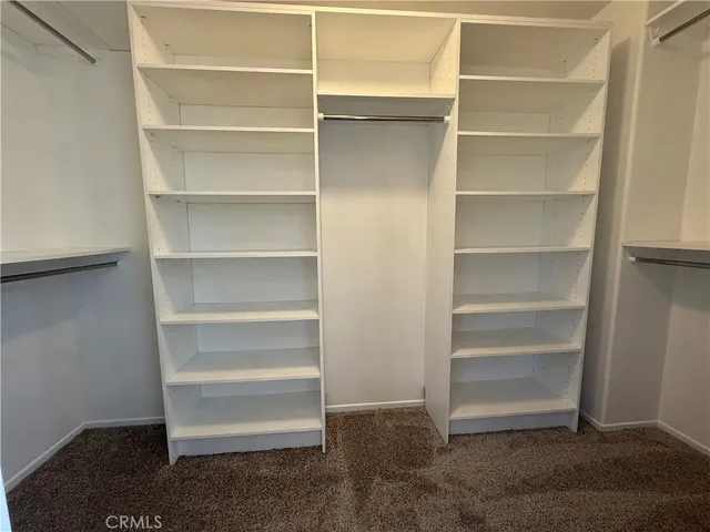 a view of walk in closet with empty racks