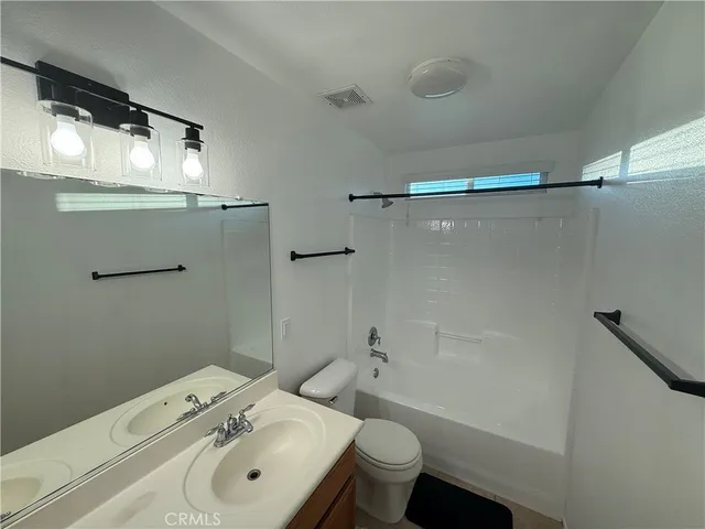 a bathroom with a sink mirror toilet and bathtub