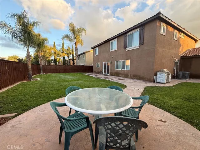 a backyard of a house with table and chairs