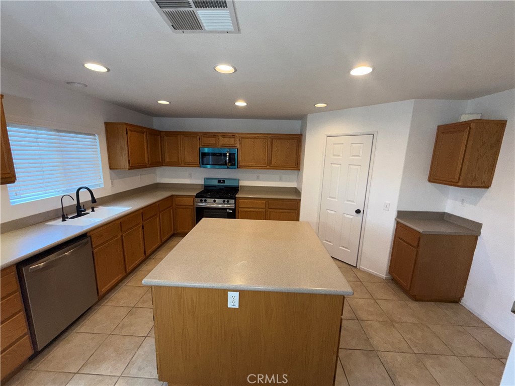 29162 Hydrangea Street Murrieta, CA 92563 - Photo 9 of 46 a large kitchen with stainless steel appliances a refrigerator and a stove top oven