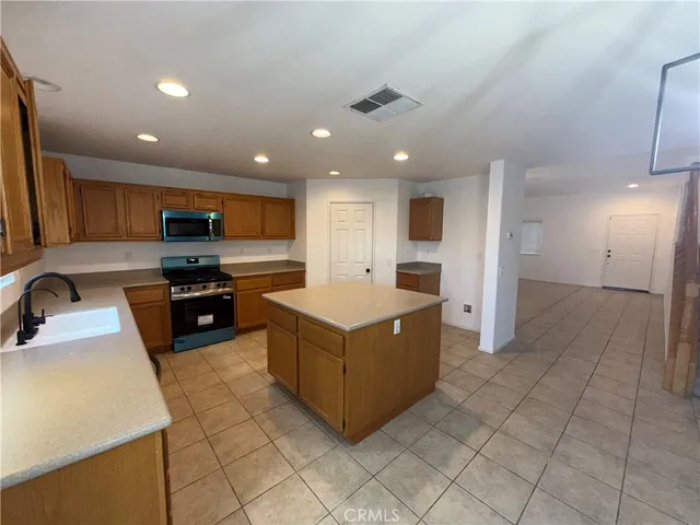 a kitchen with stainless steel appliances granite countertop a refrigerator and a stove top oven