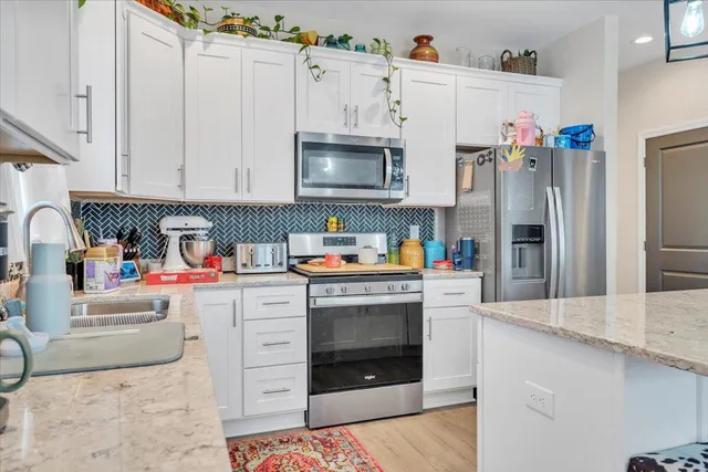 a kitchen with white cabinets and white appliances