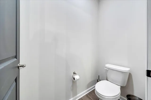 a white toilet sitting next to a white wall