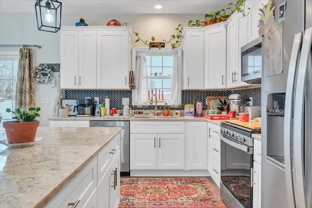 a kitchen with stainless steel appliances granite countertop a refrigerator sink and cabinets