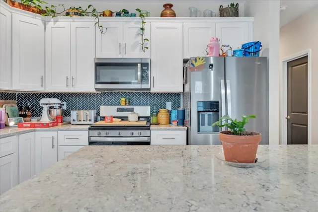 a kitchen view with cabinets and window