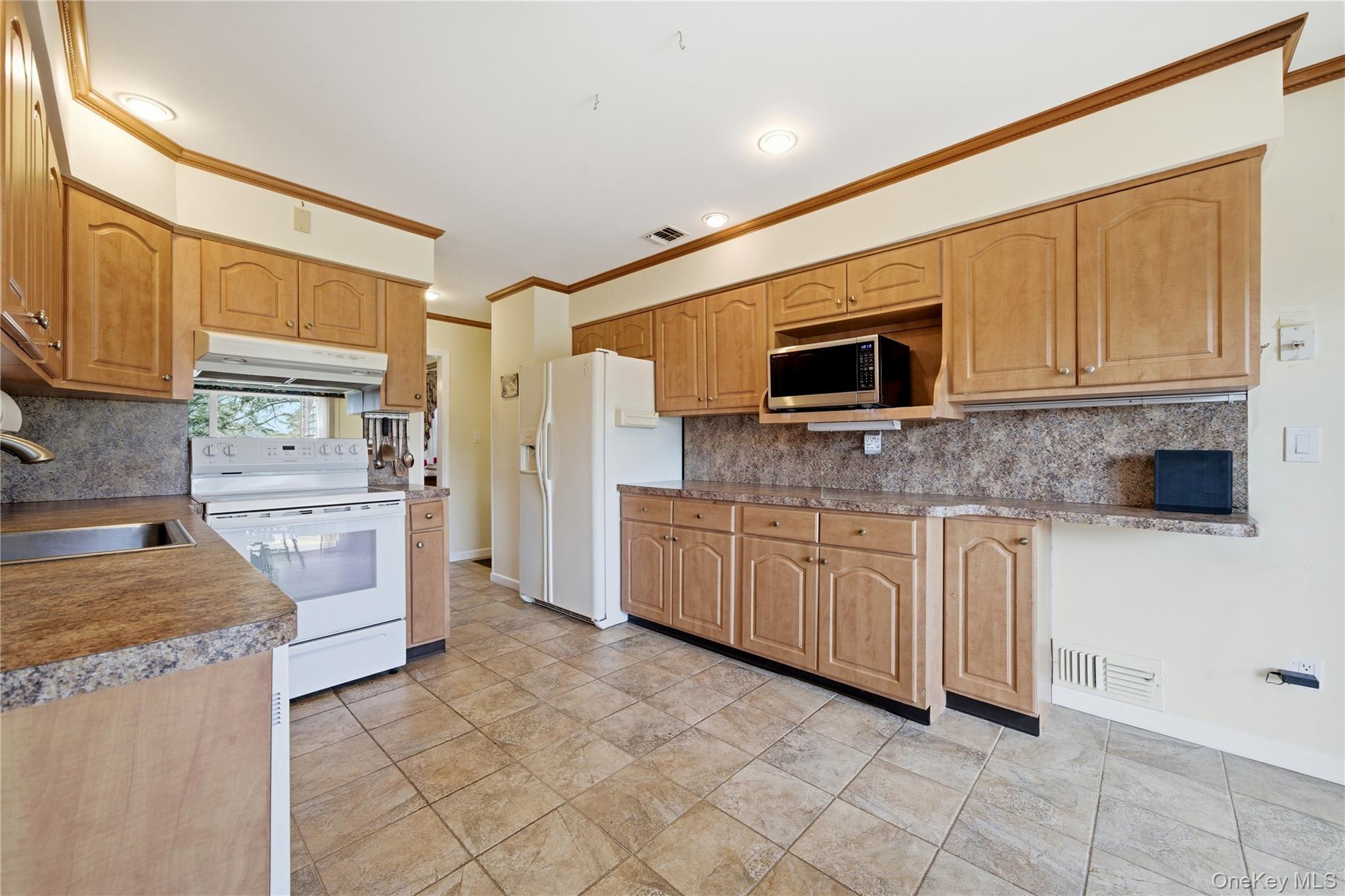 282 Helm Lane Bay Shore, NY 11706 - Photo 11 of 48 a kitchen with granite countertop a stove top oven microwave and cabinets