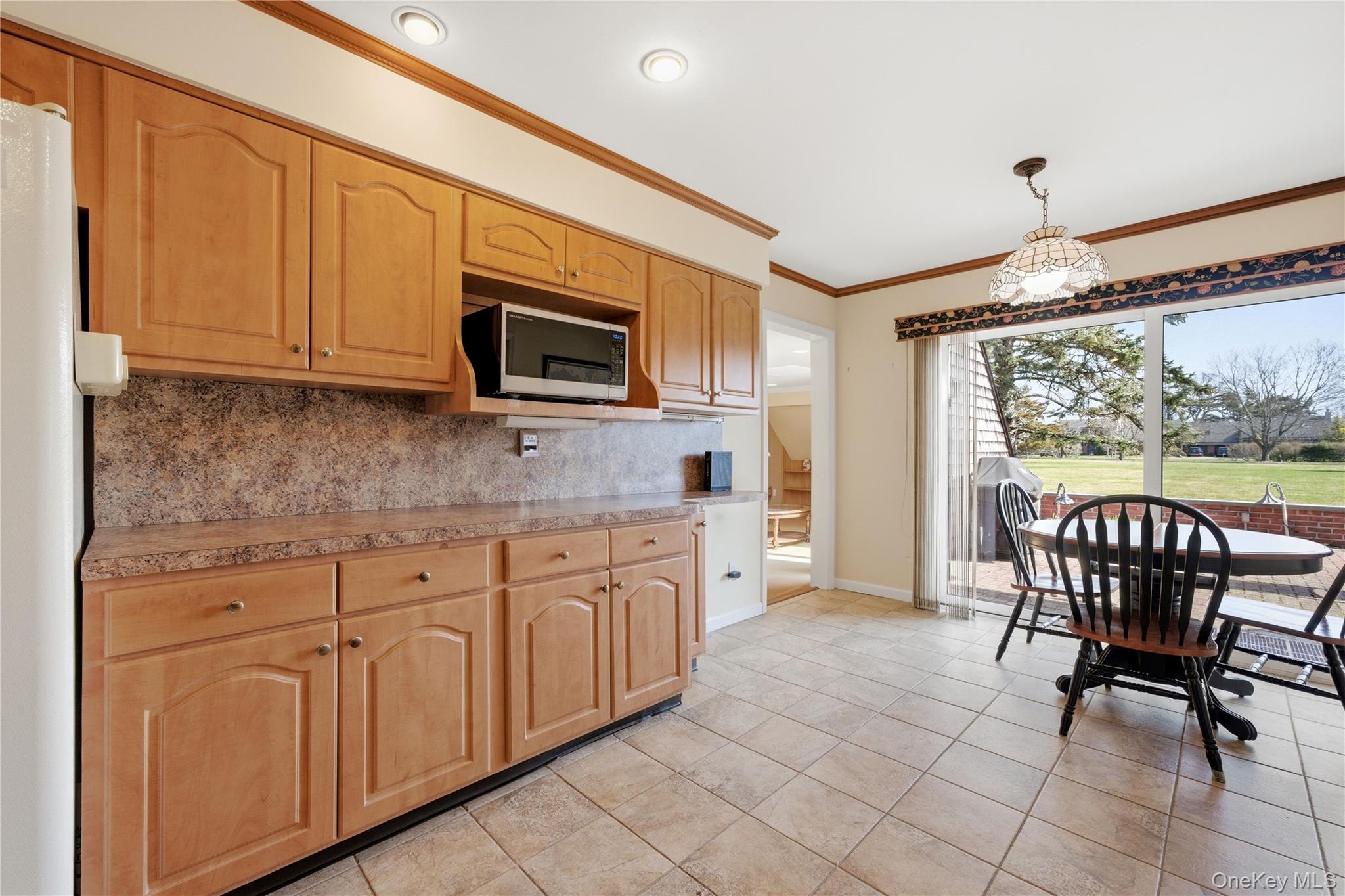 282 Helm Lane Bay Shore, NY 11706 - Photo 15 of 48 a kitchen with stainless steel appliances granite countertop a stove top oven a sink dishwasher a dining table and chairs with wooden floor