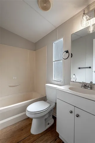 a bathroom with a toilet a sink and mirror