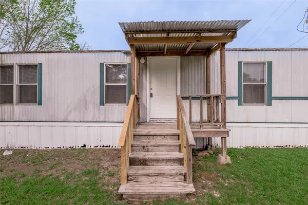a view of a house with a small yard and stairs