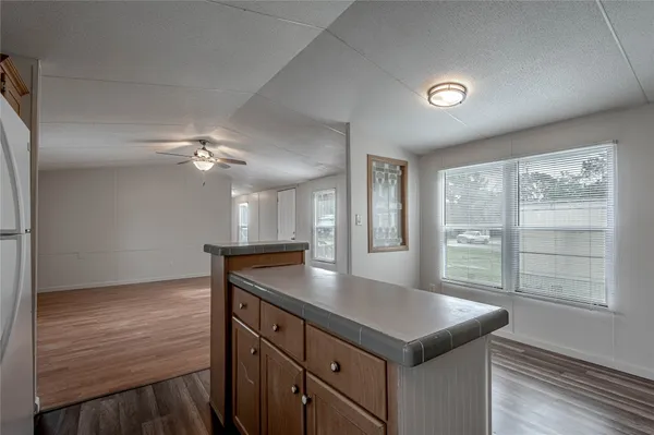 a kitchen with kitchen island granite countertop a stove and a sink