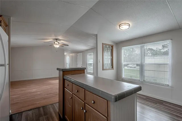 a kitchen with kitchen island granite countertop a stove and a sink