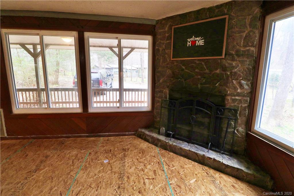 128 Home Road Mill Spring, NC 28756 - Photo 8 of 36 a living room with a fireplace and a flat screen tv