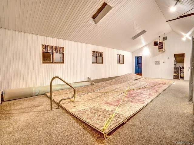 a bedroom with a bed and dresser with wooden floor