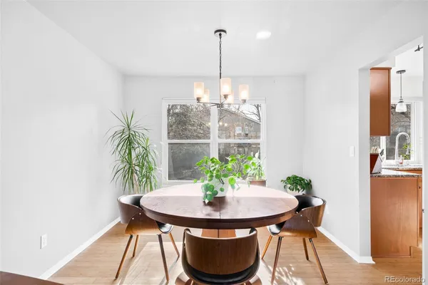 a dining room with furniture and a potted plant