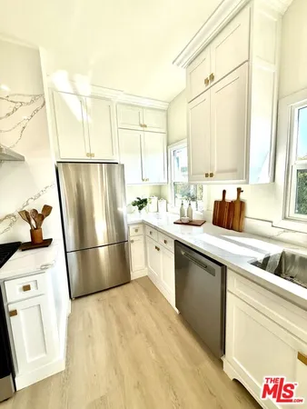 a kitchen with a sink refrigerator and cabinets