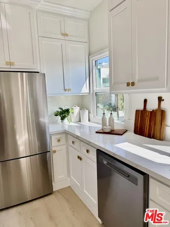 a kitchen with stainless steel appliances a refrigerator sink and cabinets