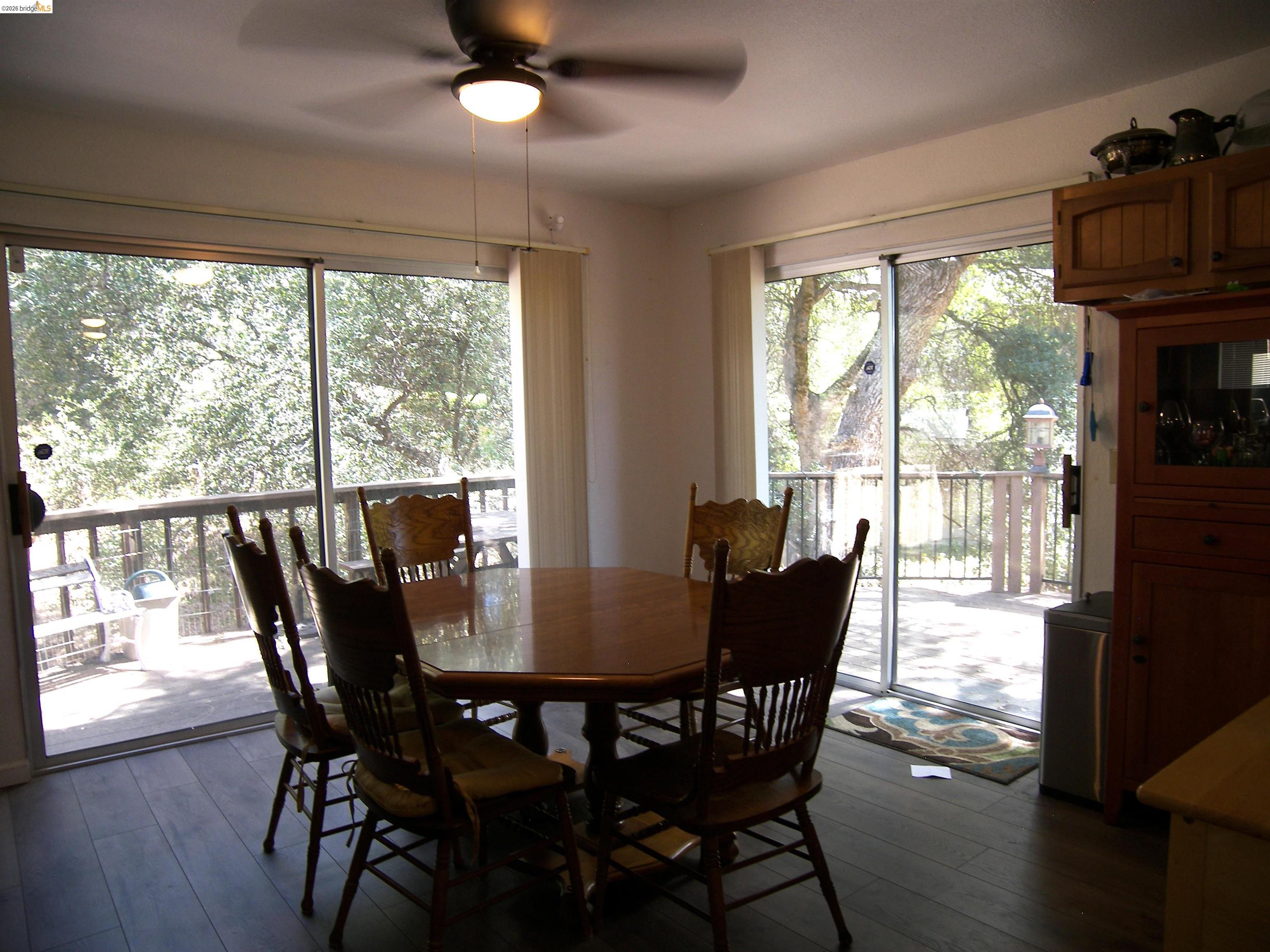 19215 Ferretti Road Groveland, CA 95321 - Photo 8 of 40 Dining area featuring wood-finish flooring, a ceiling fan with integrated lighting, and dual sliding glass doors