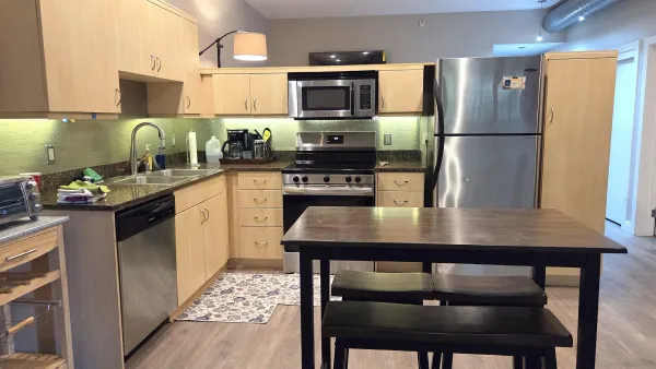 a kitchen with a table chairs refrigerator and microwave