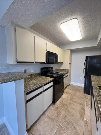 a kitchen with granite countertop a stove and a sink
