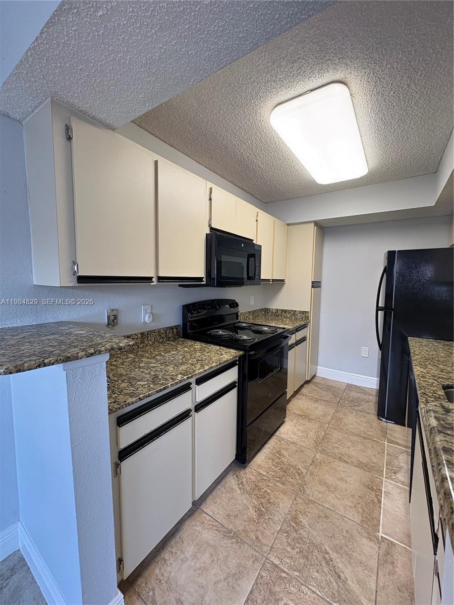10501 Southwest 155th Court, Unit 1124 Miami, FL 33196 - Photo 6 of 15 a kitchen with granite countertop a stove and a sink