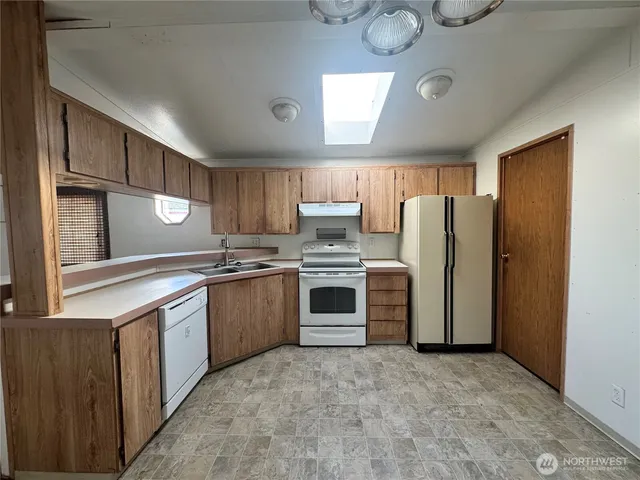 a kitchen with a refrigerator sink and cabinets